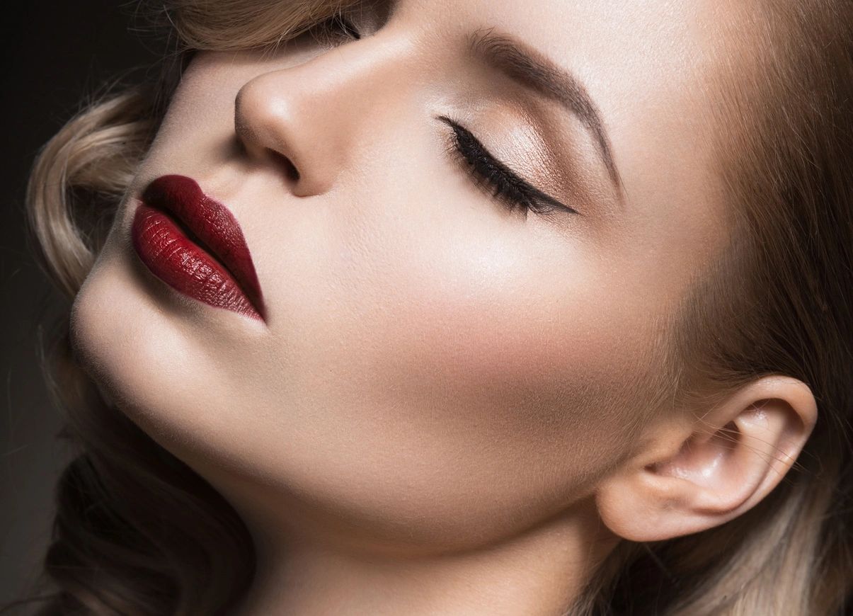 Editorial beauty portrait — sculpted brows, winged liner, deep red lips
