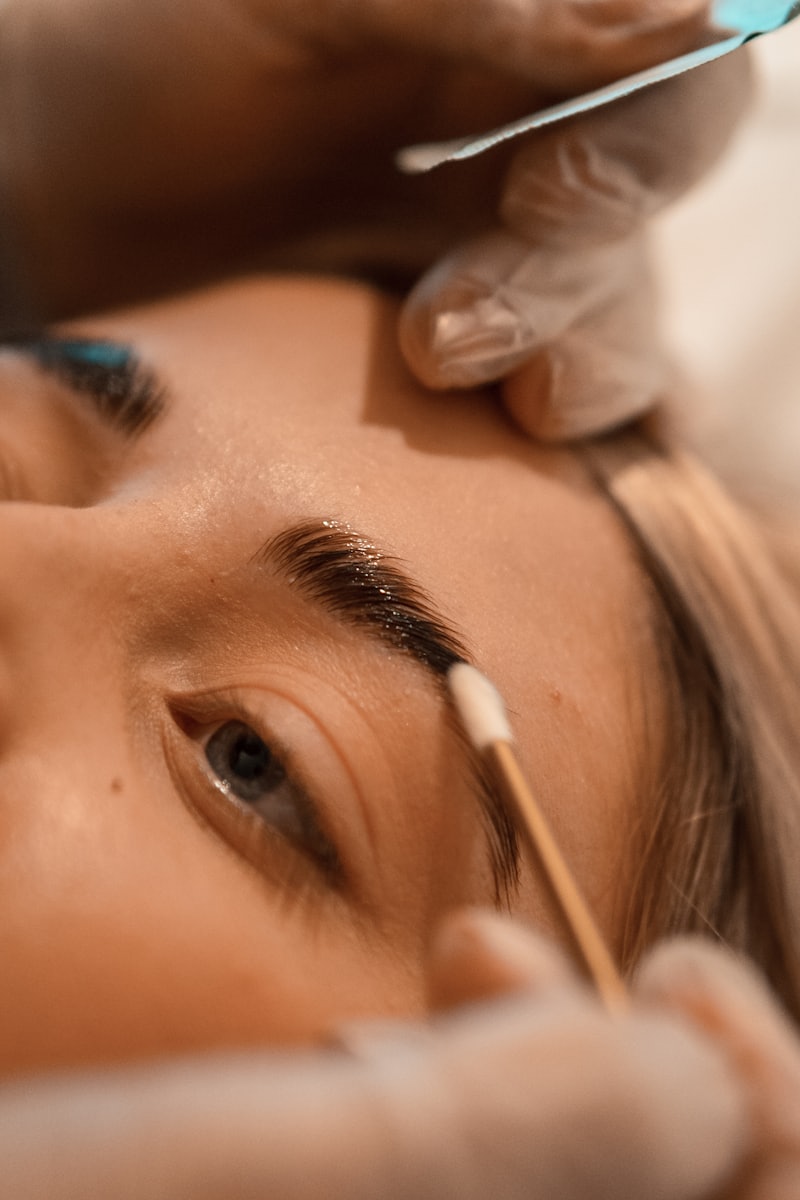 Brow product being brushed through an eyebrow during a lamination-style treatment