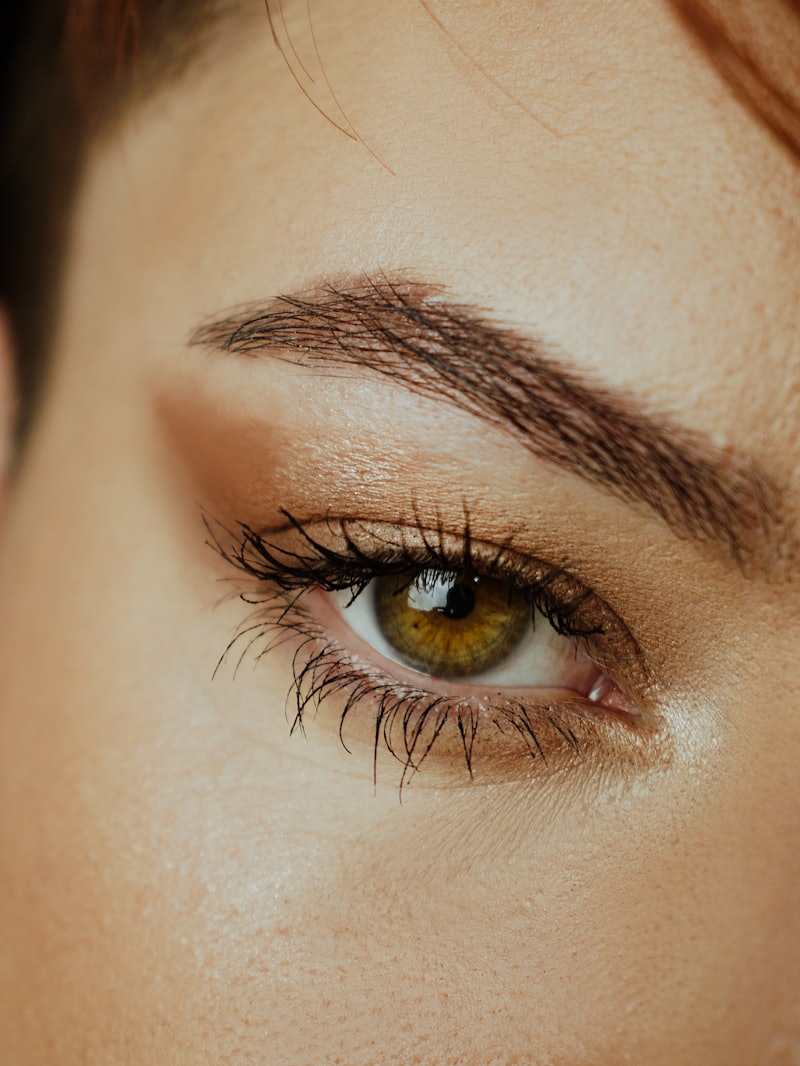 Close-up of a sculpted, tinted eyebrow with a soft golden finish